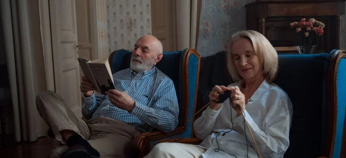 Older couple reading and knitting together at home